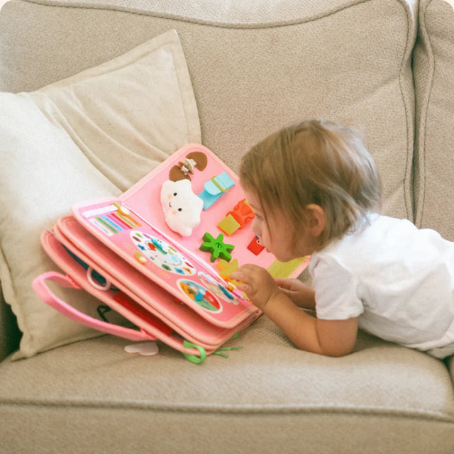 Toddler playing independently with the Busy Board at home